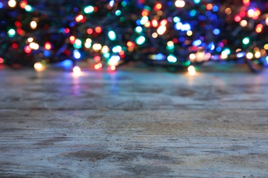 Wooden table and blurred Christmas lights on background