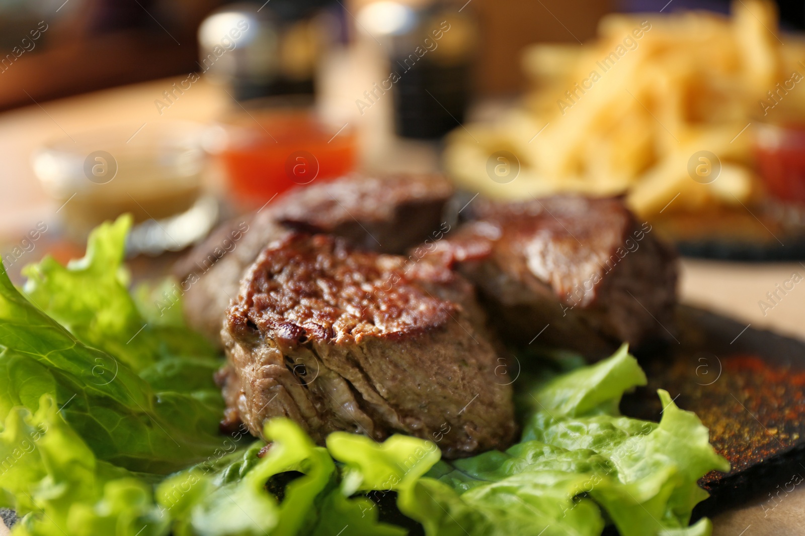 Photo of Tasty pieces of shish kebab served on slate plate in cafe