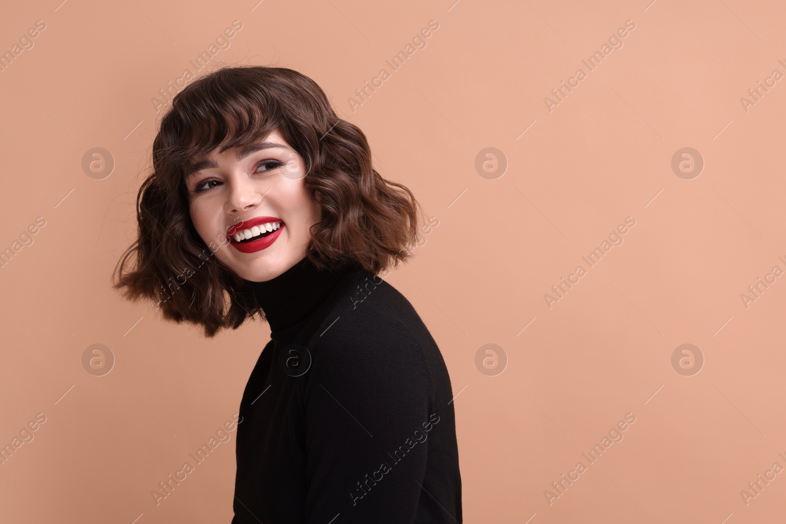 Photo of Portrait of beautiful young woman with wavy hairstyle on beige background. Space for text