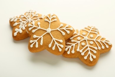 Tasty Christmas cookies with icing on white background, closeup