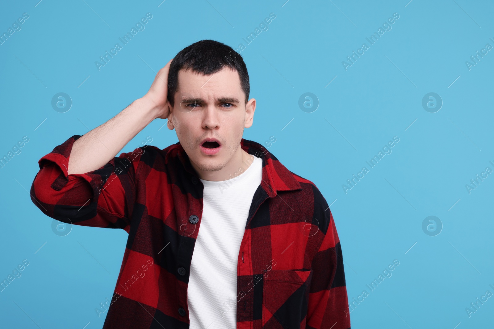 Photo of Portrait of surprised man on light blue background, space for text