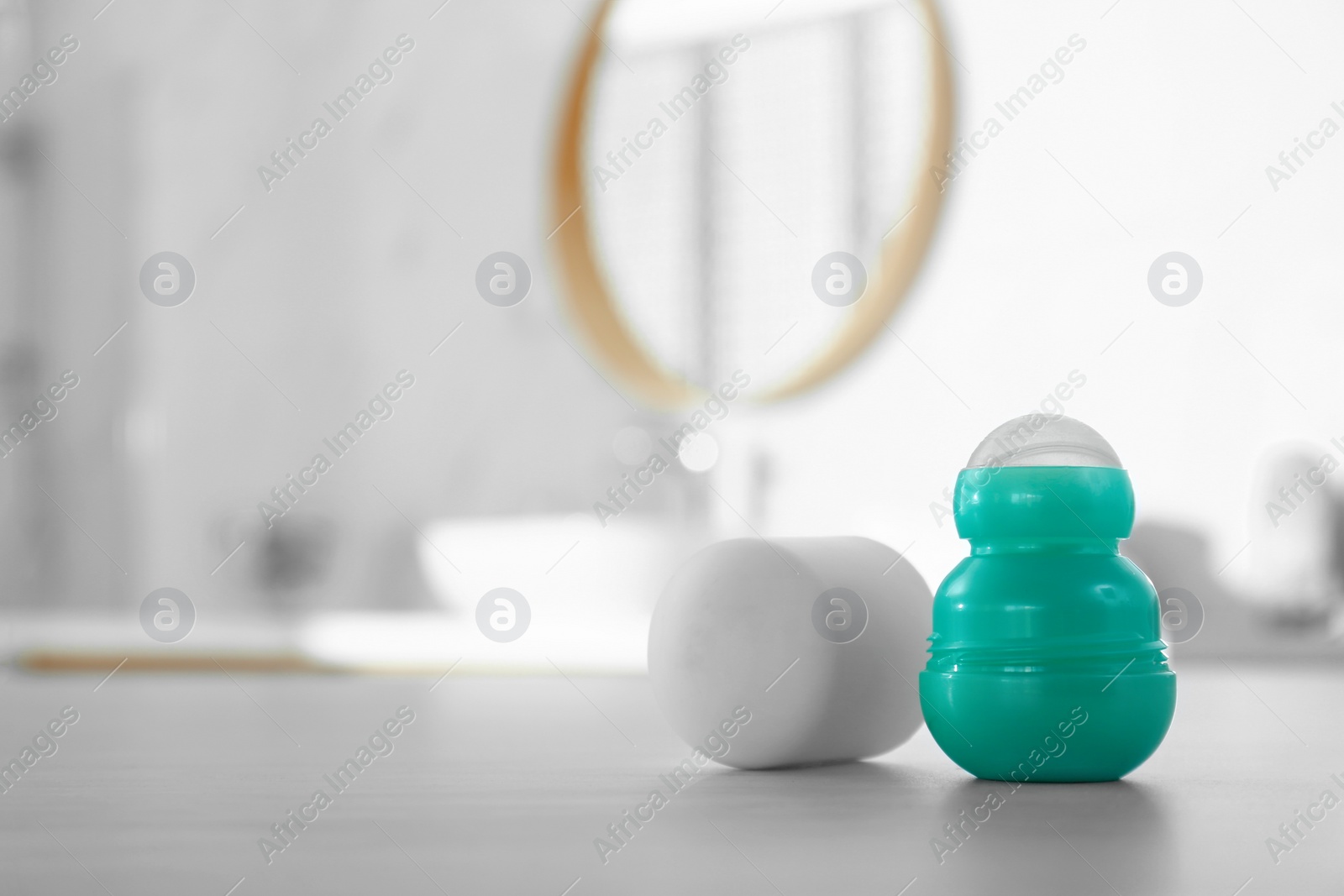 Photo of Deodorant container on table in bathroom. Space for text