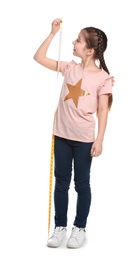 Little girl measuring her height on white background