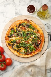 Photo of Delicious vegetarian pizza served on white marble table, flat lay