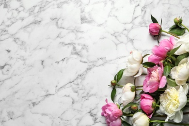 Photo of Fragrant peonies on marble table, top view with space for text. Beautiful spring flowers