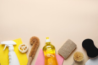 Photo of Flat lay composition with sponges and other cleaning supplies on beige background. Space for text
