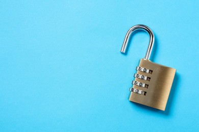 Steel combination padlock on light blue background, top view. Space for text