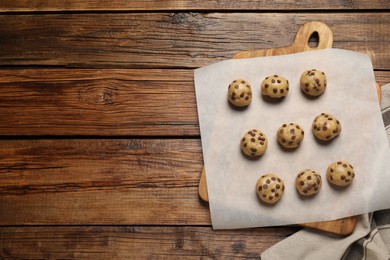 Uncooked chocolate chip cookies on wooden table, top view. Space for text
