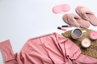 Photo of Composition with pink fluffy slippers and pajamas on white background, flat lay. Comfortable home outfit