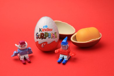 Sveti Vlas, Bulgaria - June 29, 2023: Kinder Surprise Eggs, plastic capsule and toys on red background