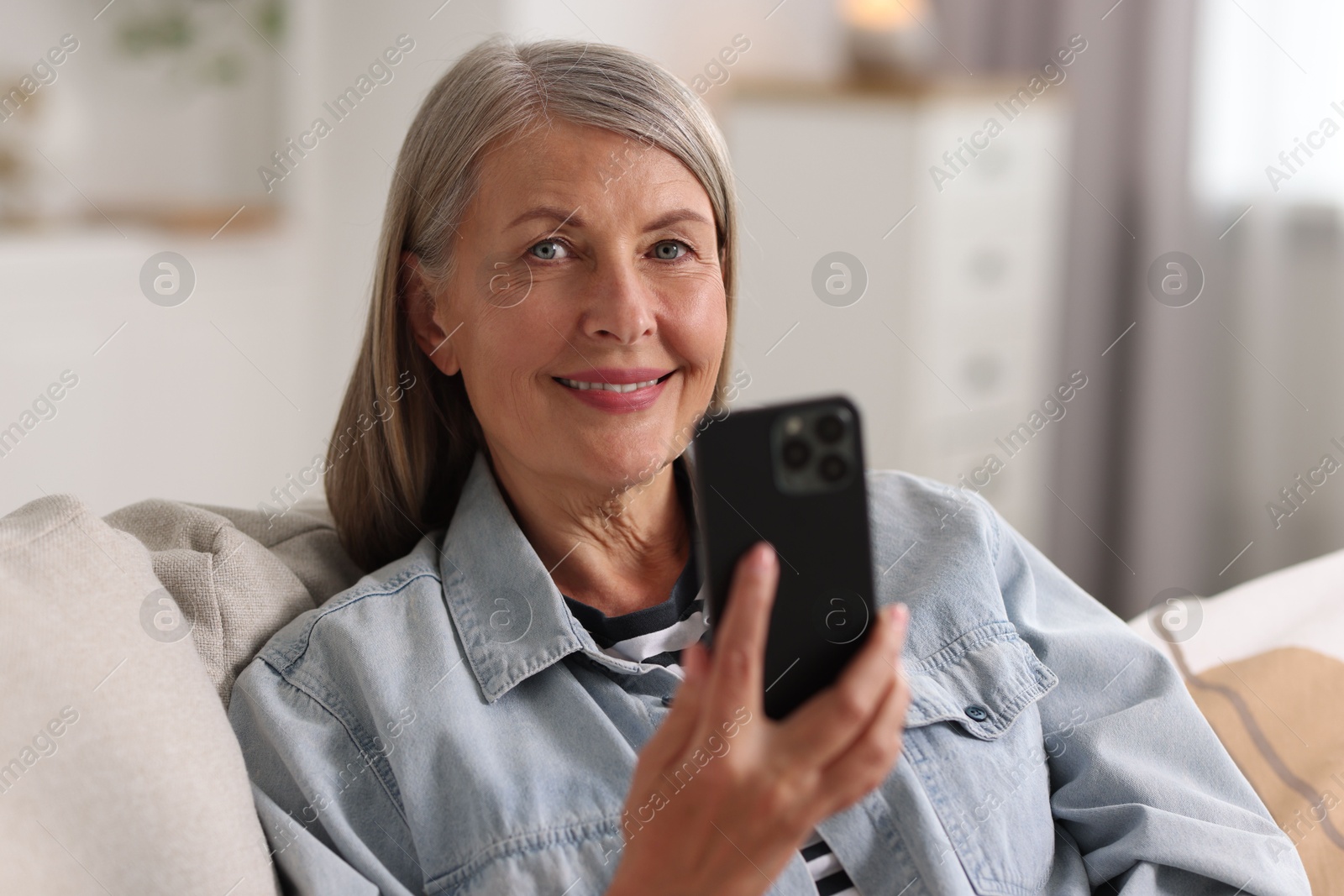 Photo of Senior woman using mobile phone at home