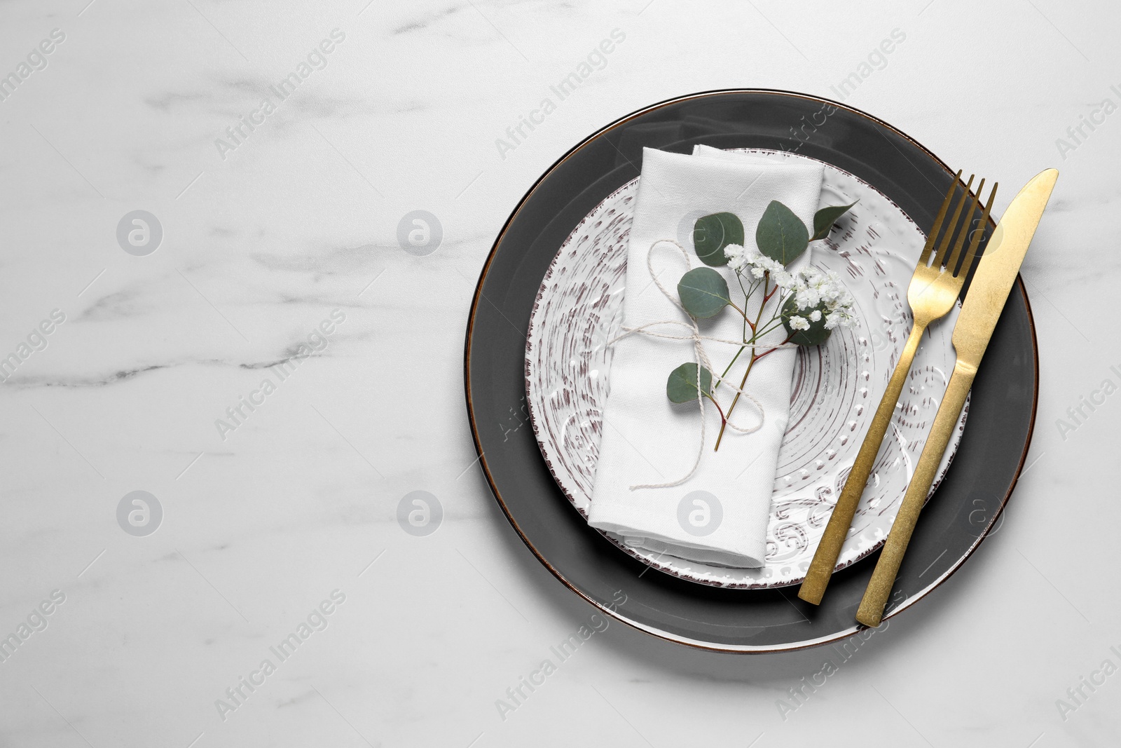 Photo of Stylish table setting with cutlery, flower and eucalyptus leaves, top view. Space for text