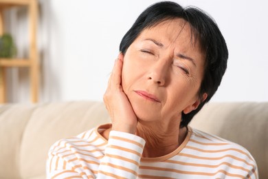 Photo of Senior woman suffering from ear pain at home