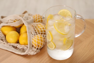 Freshly made lemonade in jug on wooden table indoors