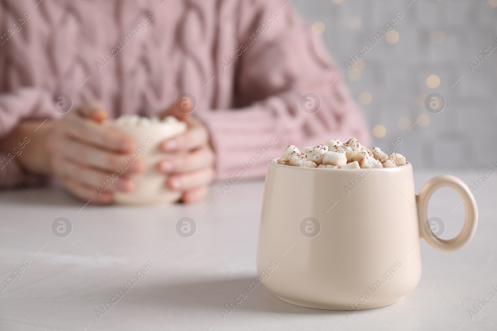 Photo of Cup of delicious hot cocoa with marshmallows on white table, space for text