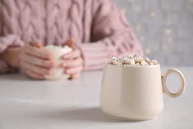 Photo of Cup of delicious hot cocoa with marshmallows on white table, space for text
