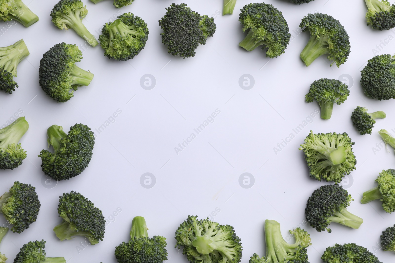 Photo of Frame made of many fresh green broccoli pieces on white background, flat lay. Space for text