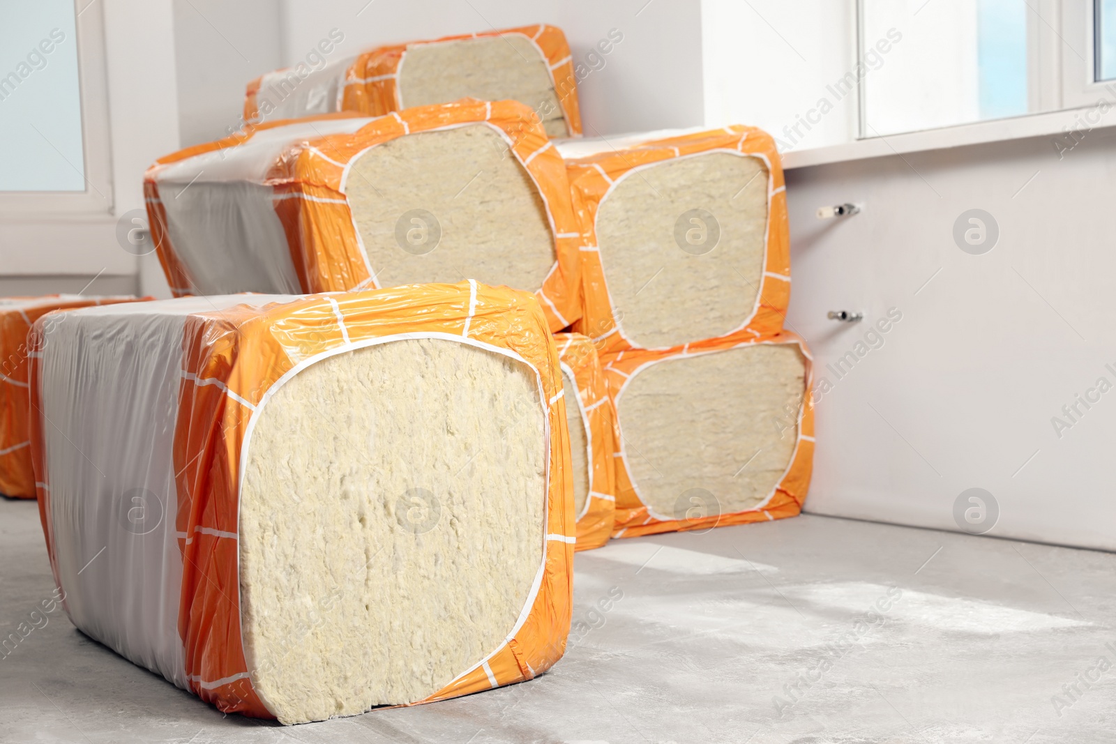 Photo of Packages of thermal insulation material in room. Space for text