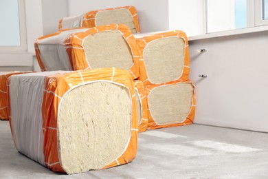 Photo of Packages of thermal insulation material in room. Space for text