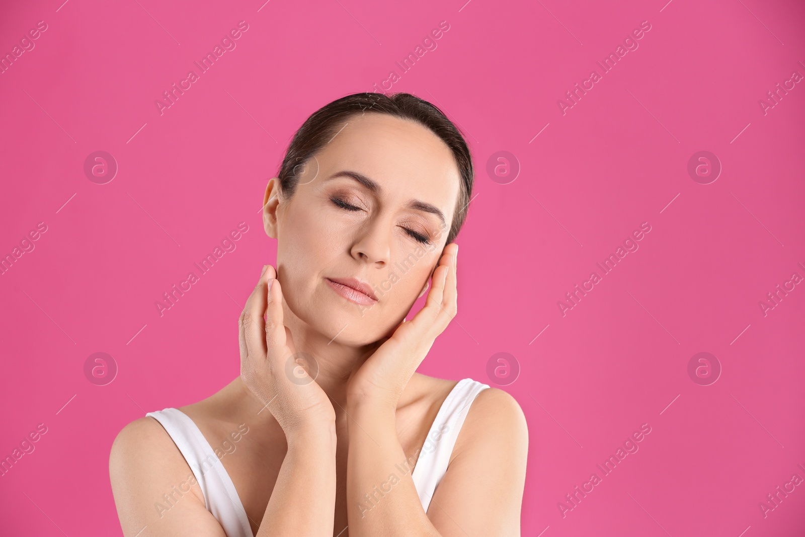 Photo of Portrait of beautiful mature woman on pink background. Space for text