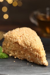 Piece of delicious Napoleon cake on gray table, closeup