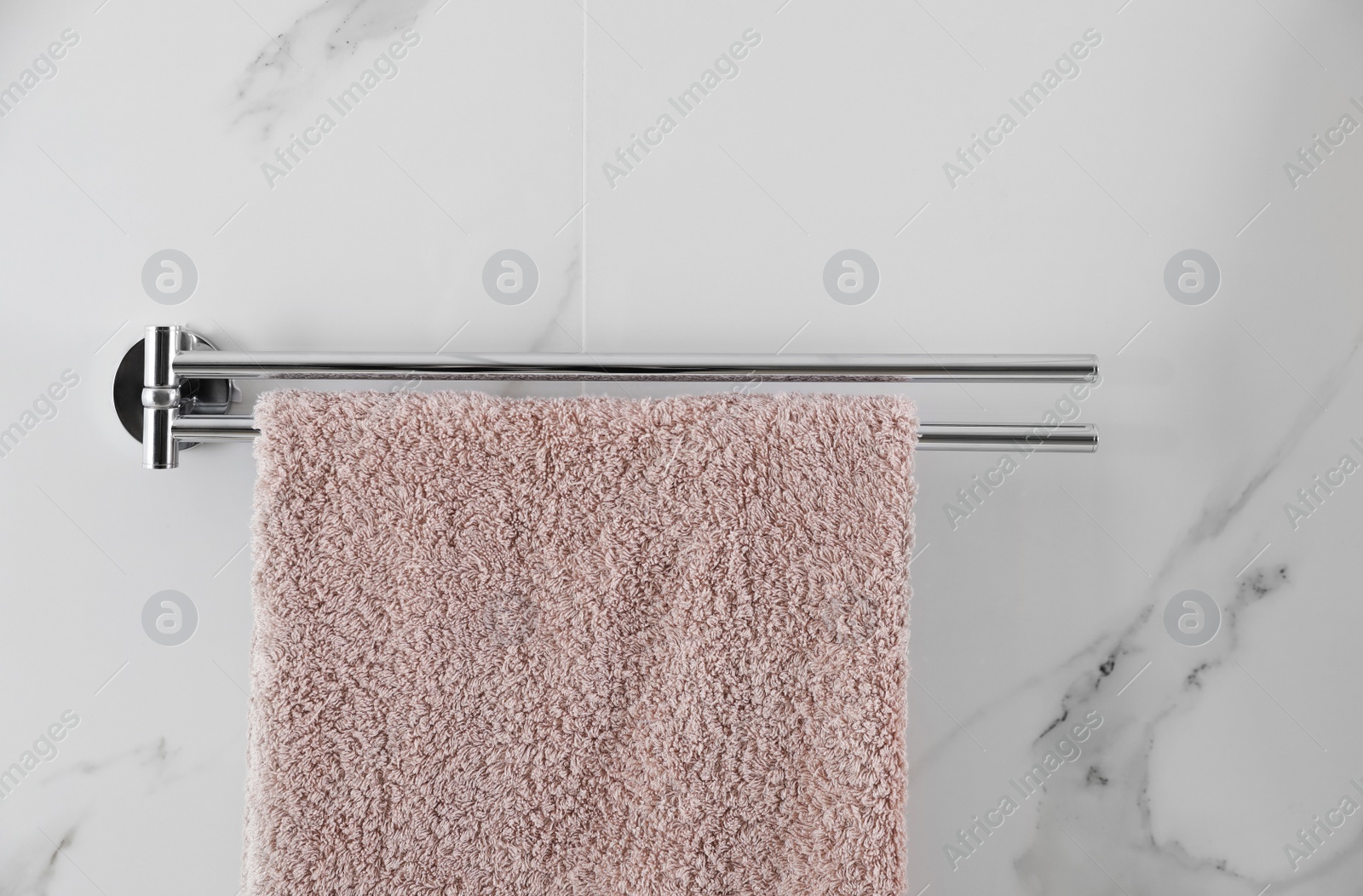 Photo of Holder with clean towel on light wall