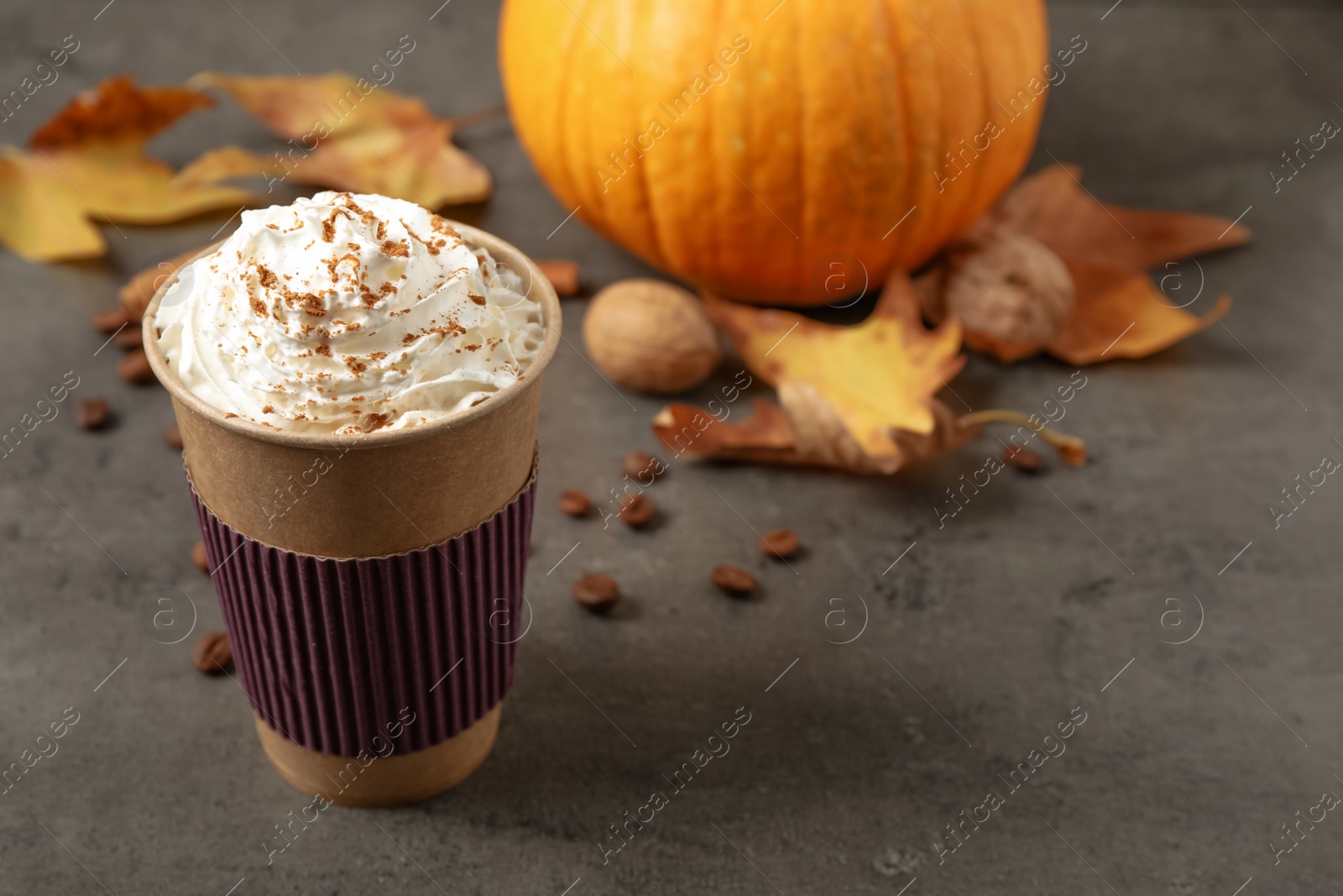 Photo of Paper cup with tasty pumpkin spice latte on grey table. Space for text