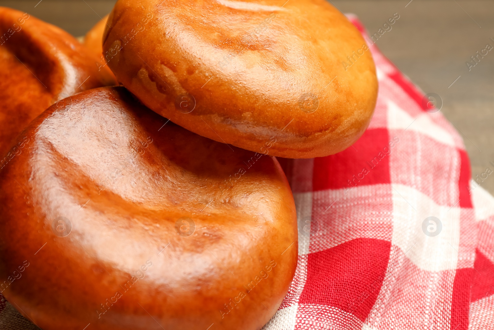 Photo of Delicious baked patties on kitchen towel, closeup