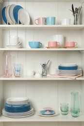 Photo of White shelving unit with set of dishware