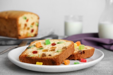 Delicious cake with candied fruits on light grey table