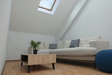 Attic room interior with slanted ceiling and furniture