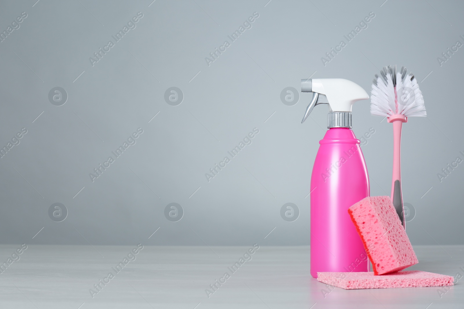 Photo of Bottle of cleaning product and supplies on light table. Space for text