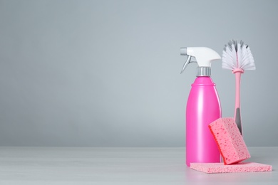 Photo of Bottle of cleaning product and supplies on light table. Space for text