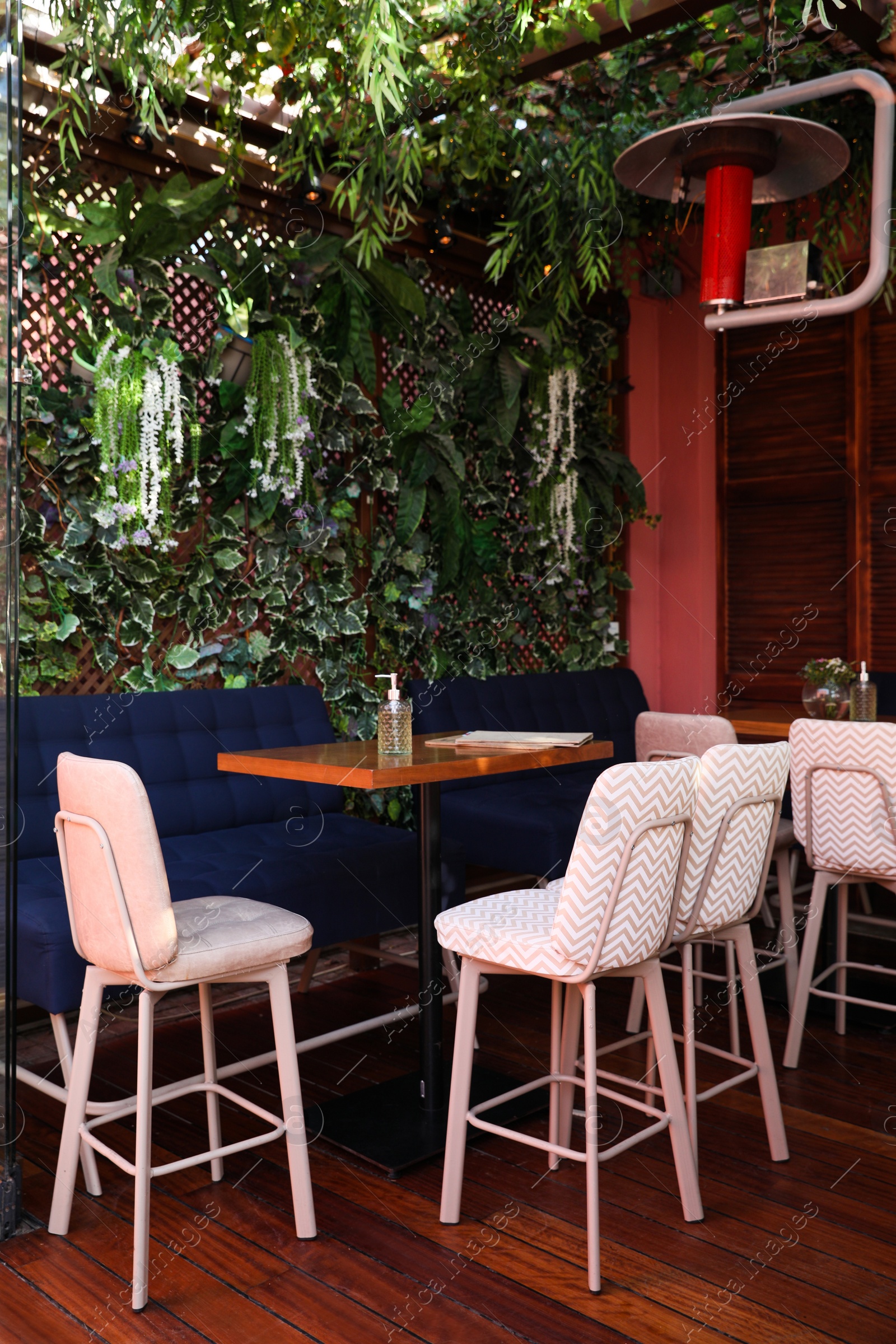 Photo of Cozy interior of cafe with modern furniture and floral decor