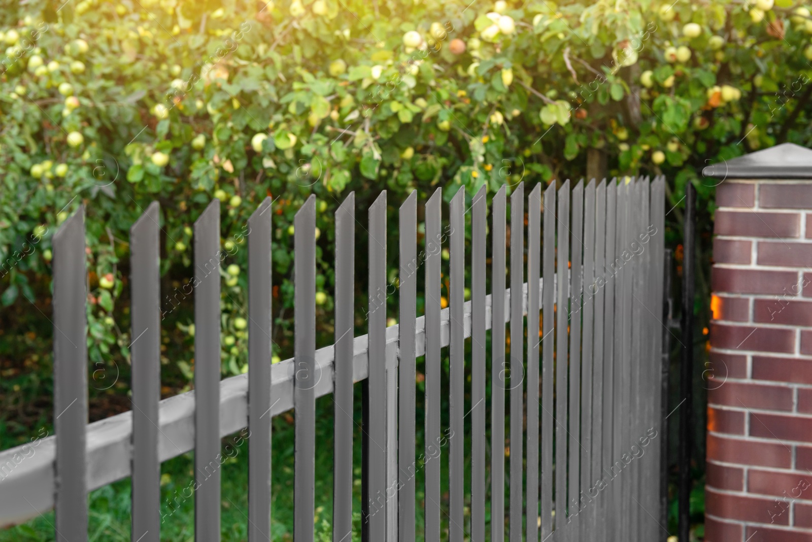 Photo of Beautiful brick fence with iron railing outdoors