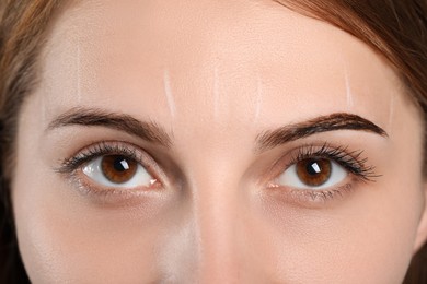 Woman during eyebrow tinting procedure, closeup view