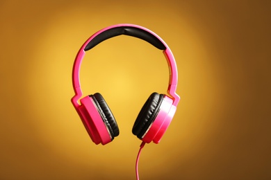 Photo of Stylish headphones with pads on color background