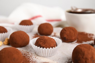 Photo of Delicious chocolate truffles powdered with cocoa on table, closeup