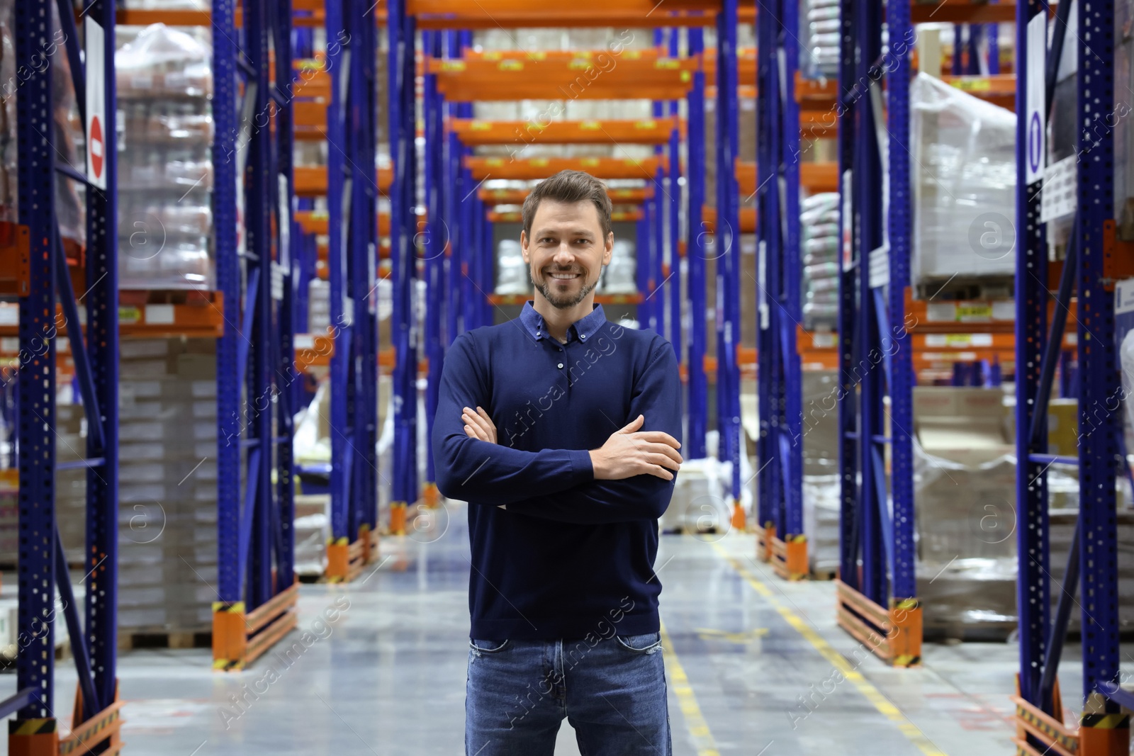 Photo of Happy manager in warehouse with lots of products