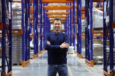 Photo of Happy manager in warehouse with lots of products