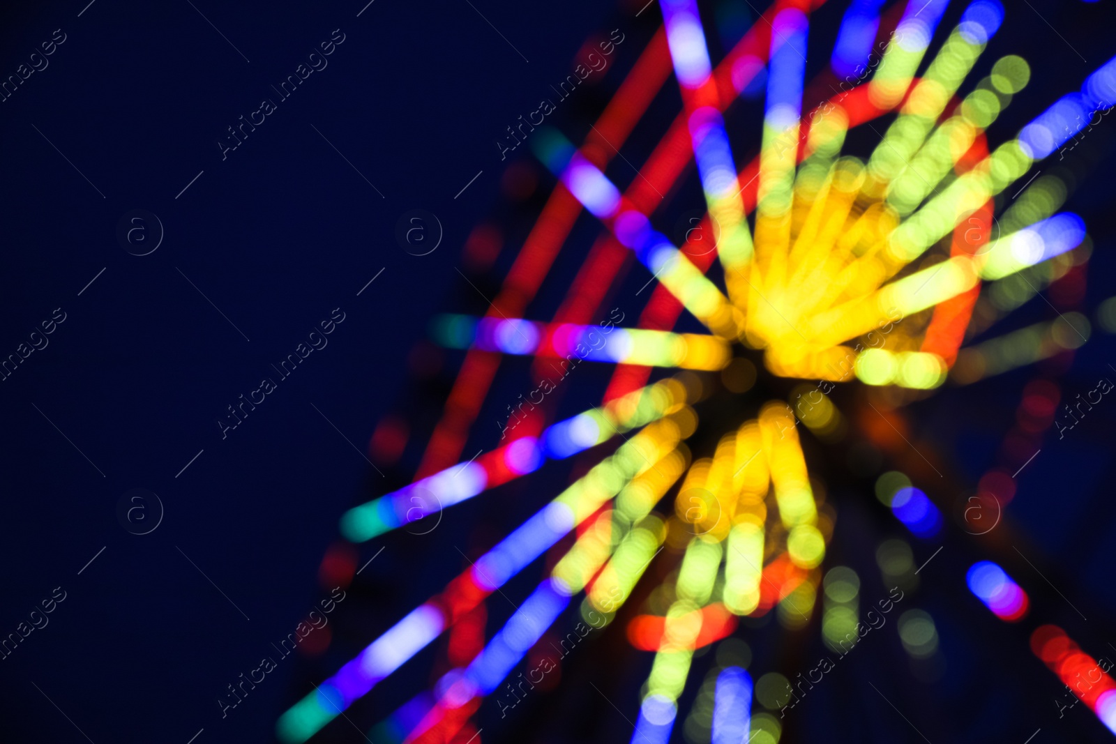 Photo of Blurred view of beautiful glowing Ferris wheel against dark sky