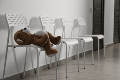 Photo of Cute teddy bear left on chair indoors. Space for text