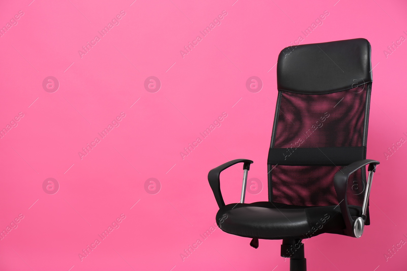 Photo of Comfortable office chair on pink background, space for text