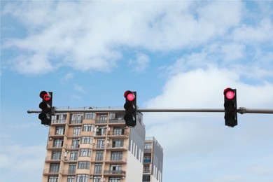 Photo of Modern traffic lights in city against cloudy sky