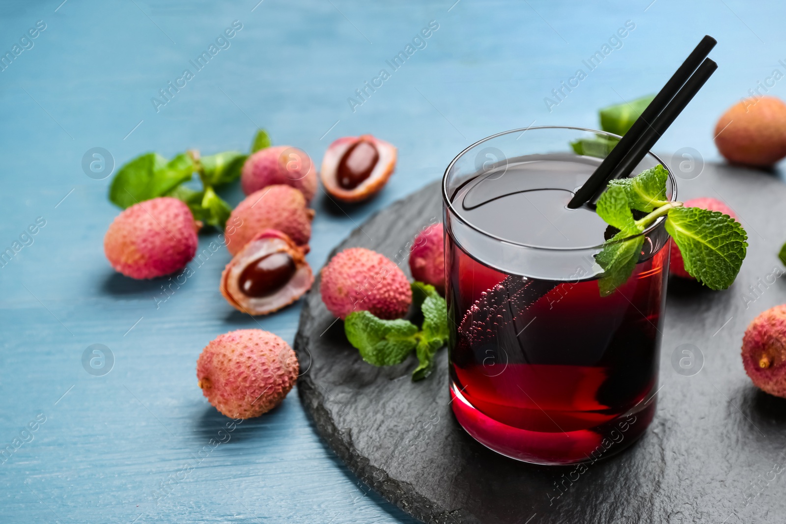 Photo of Delicious lychee cocktail with mint on light blue wooden table. Space for text