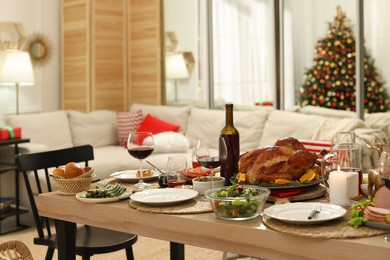 Photo of Festive dinner with delicious food and wine on table indoors. Christmas celebration