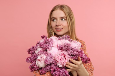 Photo of Beautiful woman with bouquet of spring flowers on pink background