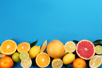 Flat lay composition with tangerines and different citrus fruits on blue background. Space for text