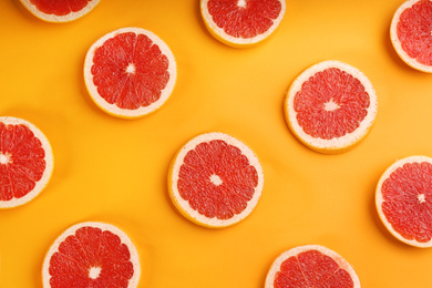 Photo of Flat lay composition with tasty ripe grapefruit slices on orange background