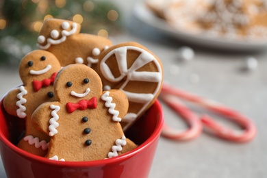 Photo of Tasty homemade Christmas cookies in cup on grey table, closeup view